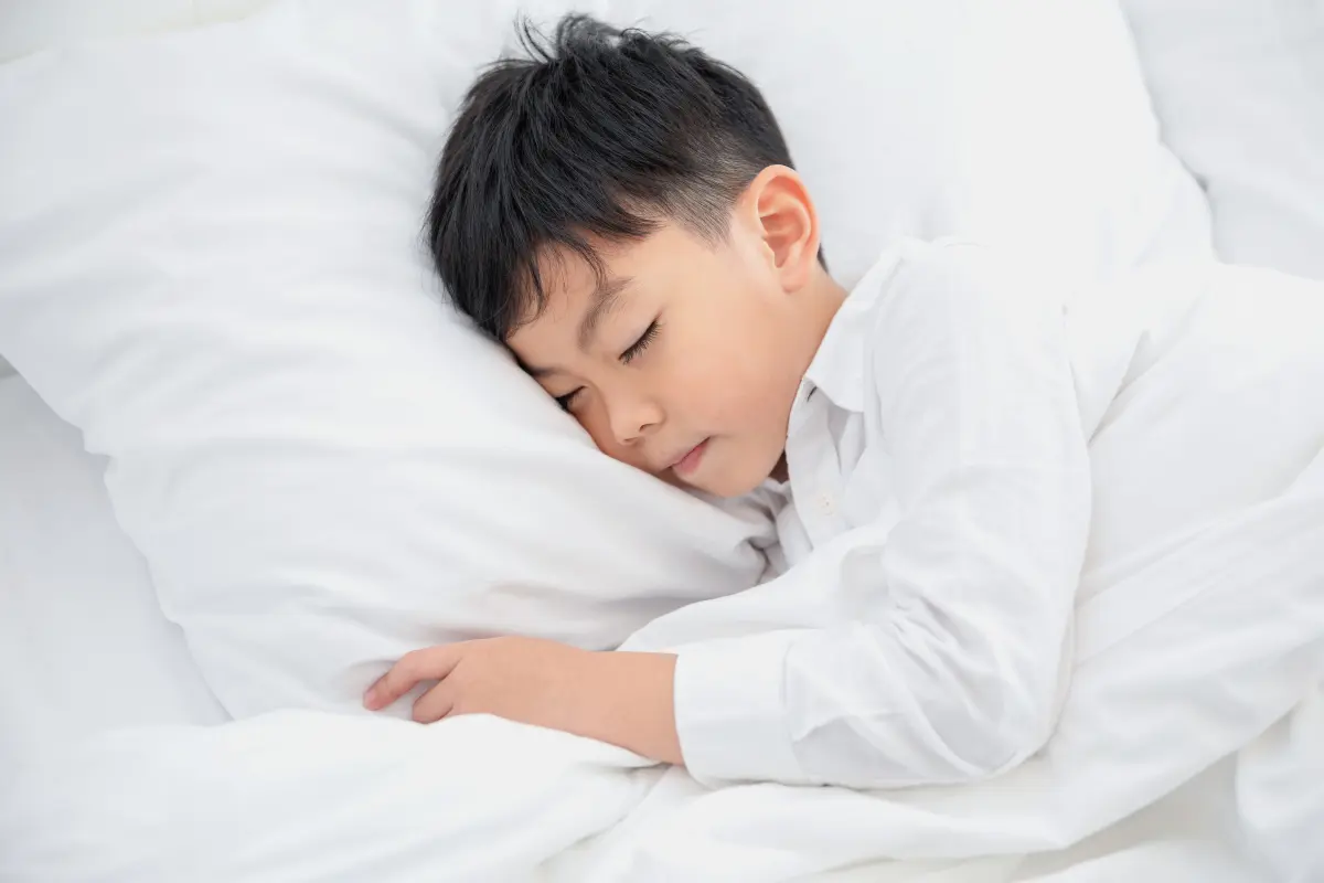  一個嬰兒睡在過高的成人枕頭上，脖子彎曲，看起來不舒服